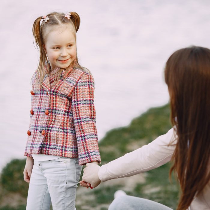 Beautiful family in a park. Woman in a white shirt and jacket. Mother with daughter.